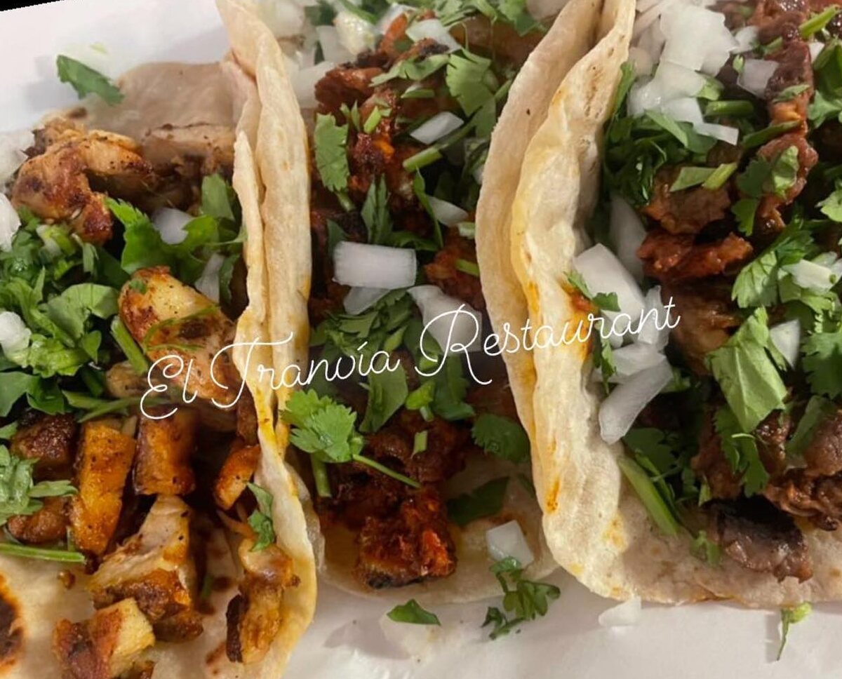 Three tacos on handmade flour tortillas, heaped with meat, onion and cilantro